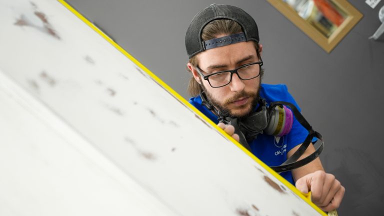 Paint technician prepping an interior piece for painting