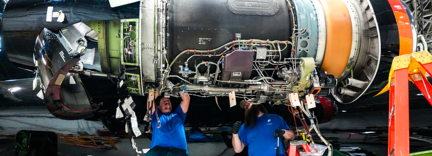 Two Aircraft Mechanics Working on an ERJ Engine